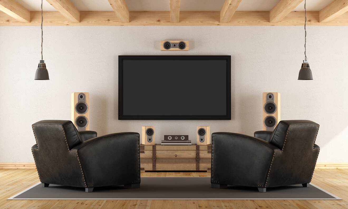 A custom disc & streaming home theater setup with two lounge chairs framing a large TV display, surrounded by amp speakers.