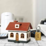 home security systems image with house and lock sitting on house plans