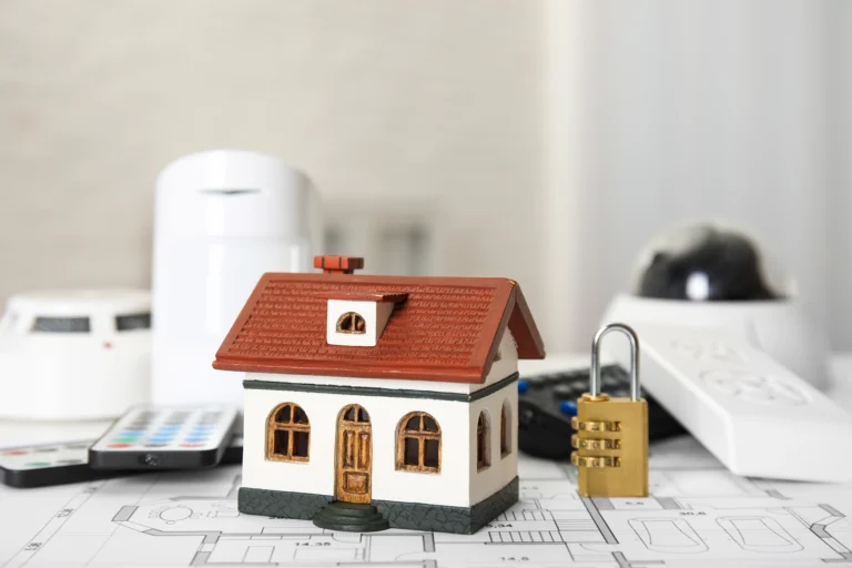 home security systems image with house and lock sitting on house plans